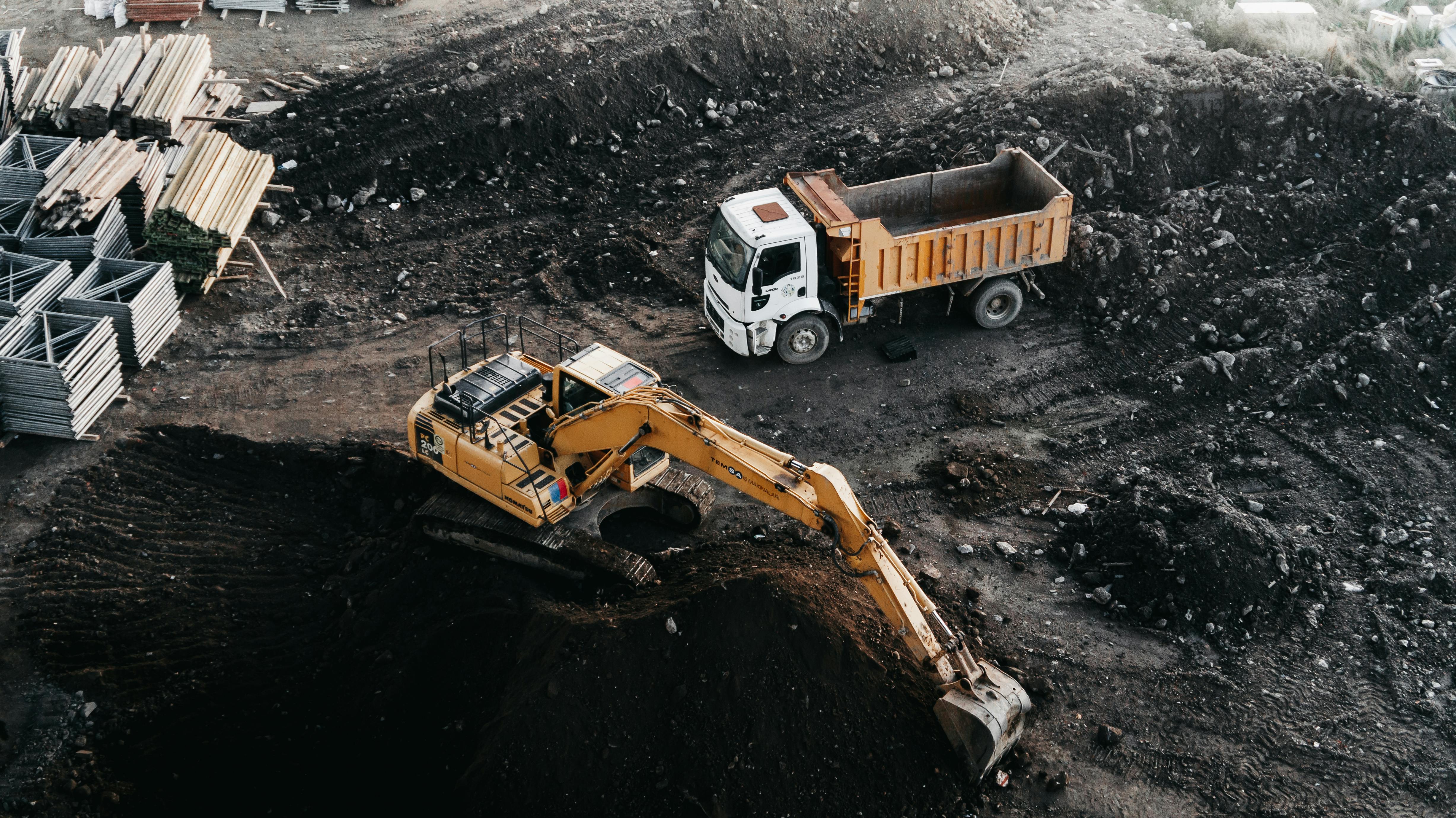 Aerial perspective of an excavation and hauling unit in an operational cycle; illustrating the maximization of hourly value and asset residual health under rigorous technical standards